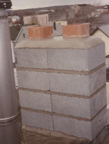 After: the rebuilt brick chimney with several flues and new caps