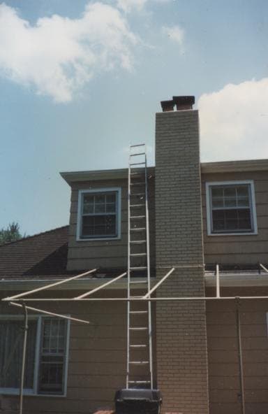 The chimney taken down to the roofline with a ladder set up for the rebuild