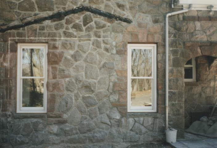 After: the finished stone wall with two new windows blended into the original stonework