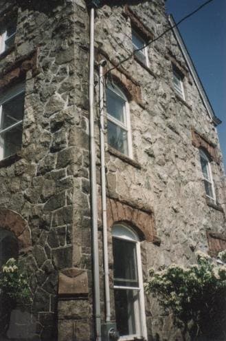 Restored stone wall with an arched stone entryway in Madison, NJ