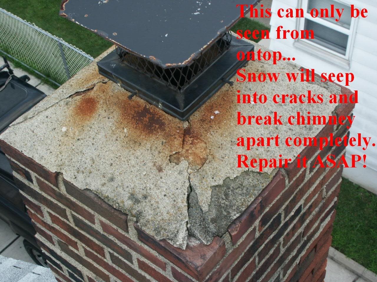 A close view of a badly cracked and broken concrete chimney crown with rust staining, red note saying snow will seep into the cracks and break the chimney apart